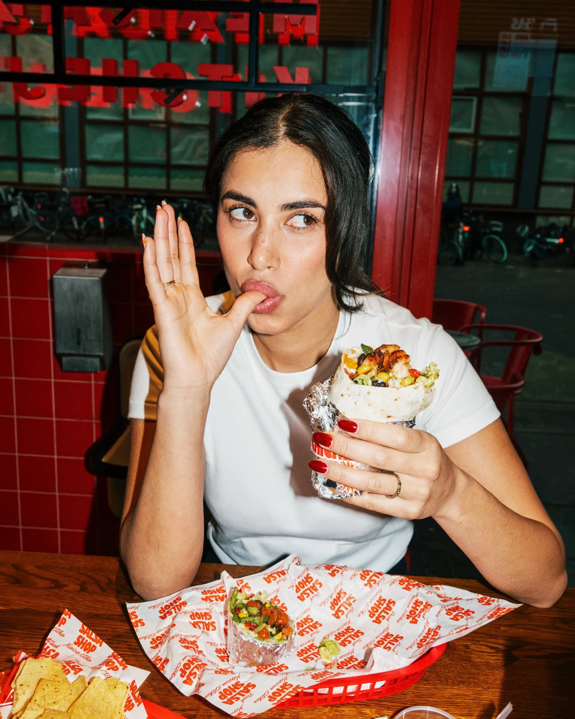 A guest savouring a fresh Salsa Shop chicken burrito